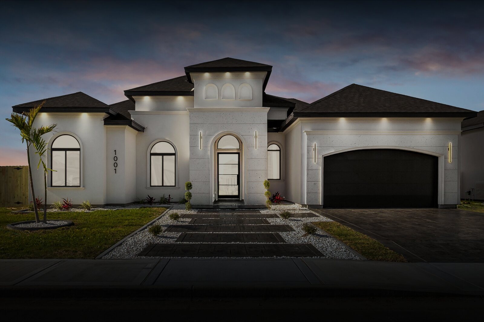 image Custom stucco home with arched entry and landscaped drive at dusk, McAllen, Texas