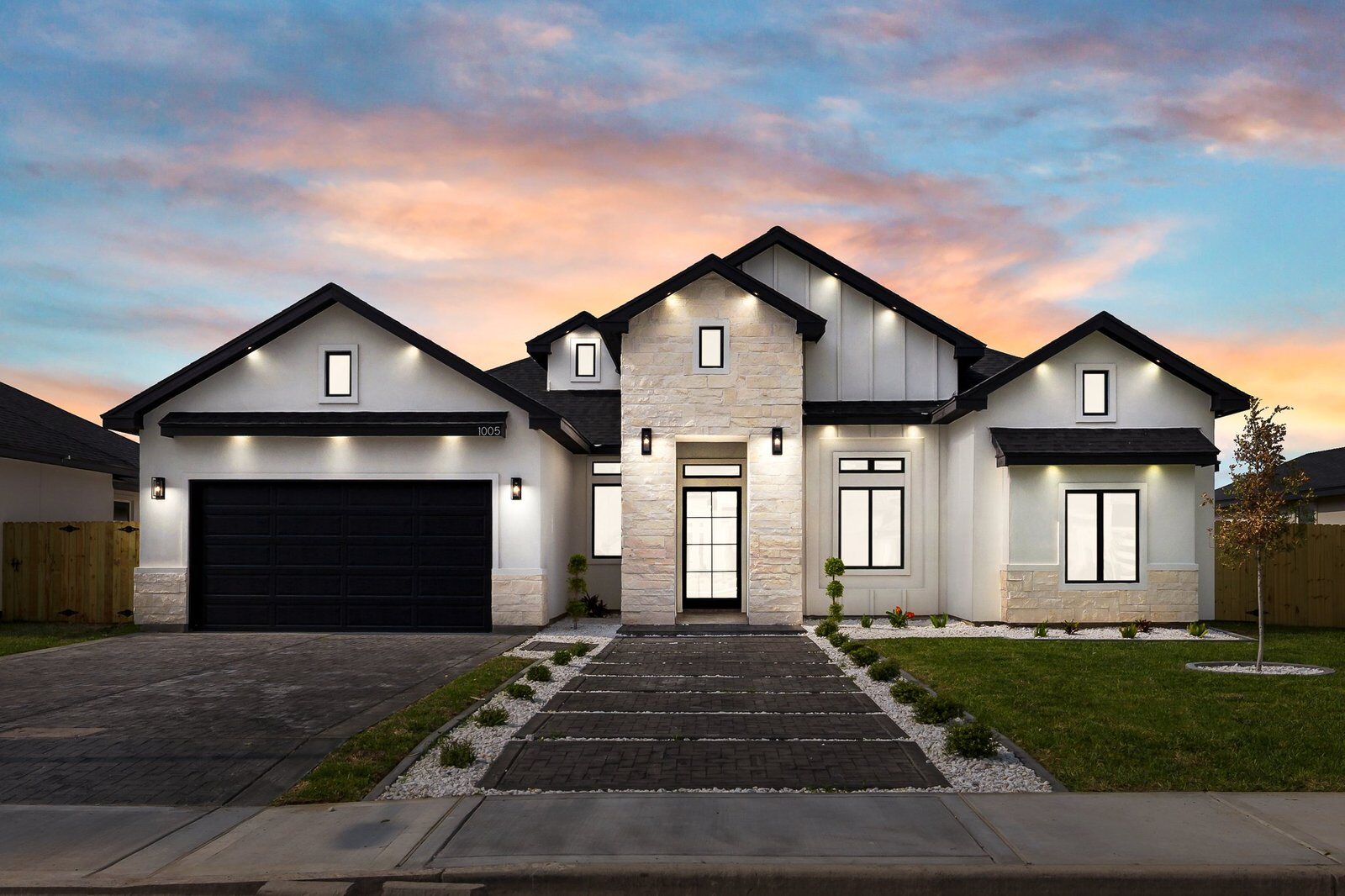 Custom home exterior at dusk with warm entry lighting, Rio Grande Valley.